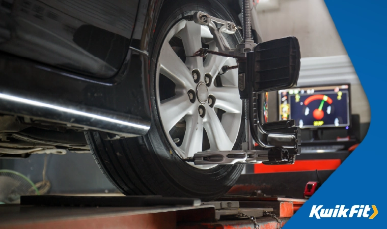 Wheel alignment equipment is used on a car.